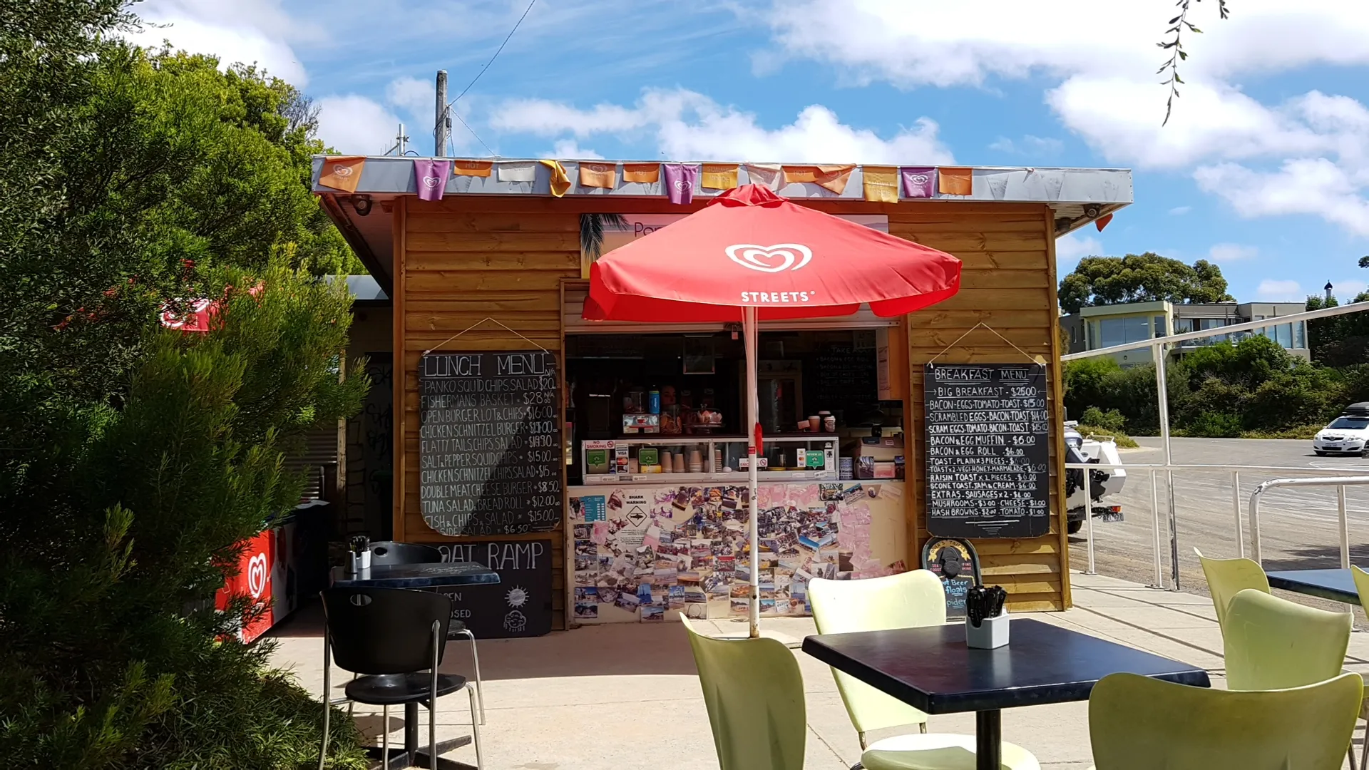 Boatramp Cafe kiosk with chalkboard menus, red umbrella and lime-green outdoor chairs
