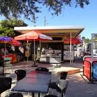 Boatramp Cafe kiosk exterior with red umbrellas and outdoor seating on a sunny day